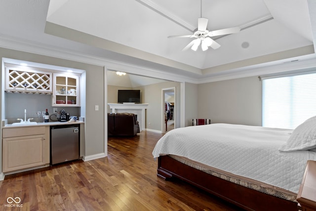 4763 Woods Edge Dr, Zionsville, IN 46077 - bedroom with a tray ceiling, bar with sink, fridge, wood finished floors, and a walk in closet