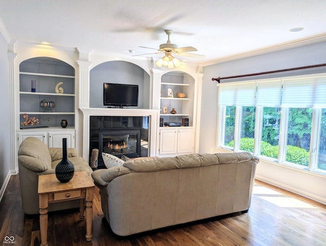 4763 Woods Edge Dr, Zionsville, IN 46077 - living room with crown molding, hardwood / wood-style floors, a glass covered fireplace, built in features, and a ceiling fan