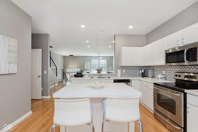 8425 Codesa Way, Indianapolis, IN 46278 - kitchen with appliances with stainless steel finishes, a sink, decorative backsplash, light wood-style flooring, and recessed lighting