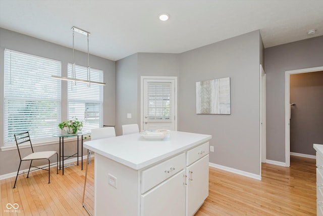 8425 Codesa Way, Indianapolis, IN 46278 - kitchen featuring light wood-type flooring, a chandelier, a kitchen island, baseboards, and white cabinets