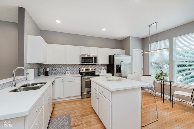 8425 Codesa Way, Indianapolis, IN 46278 - kitchen with stainless steel appliances, a sink, tasteful backsplash, light wood-style floors, and a center island