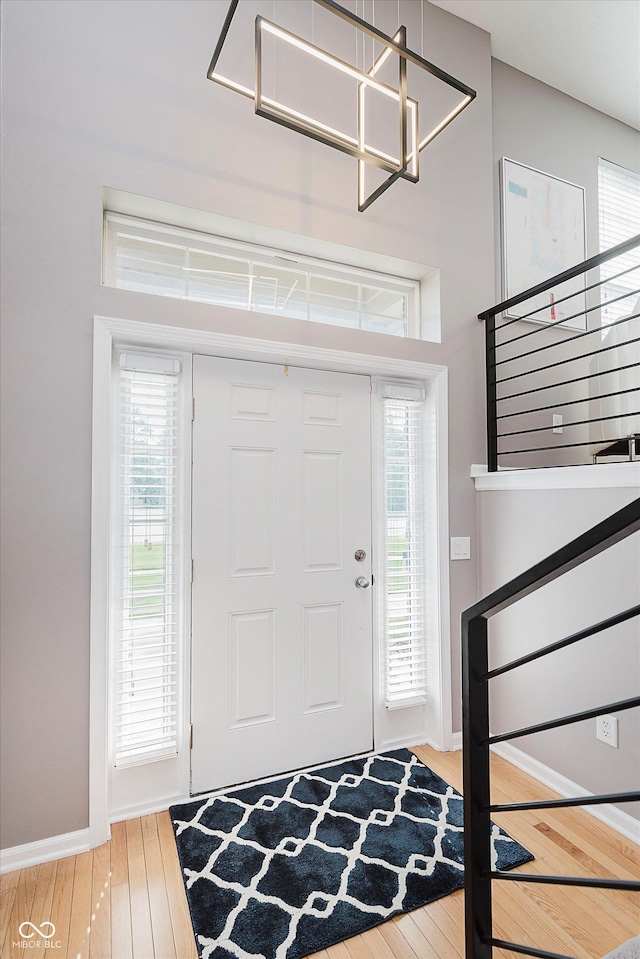 8425 Codesa Way, Indianapolis, IN 46278 - foyer entrance featuring wood finished floors, baseboards, a chandelier, and stairs