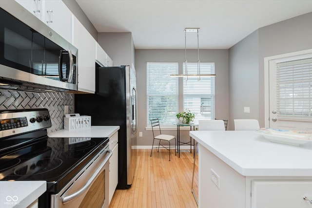8425 Codesa Way, Indianapolis, IN 46278 - kitchen with stainless steel appliances, white cabinets, light wood finished floors, light countertops, and baseboards