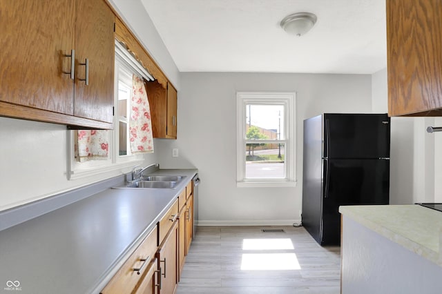 11 14th St, Franklin, IN 46131 - kitchen with freestanding refrigerator, a sink, light wood-style flooring, and brown cabinets