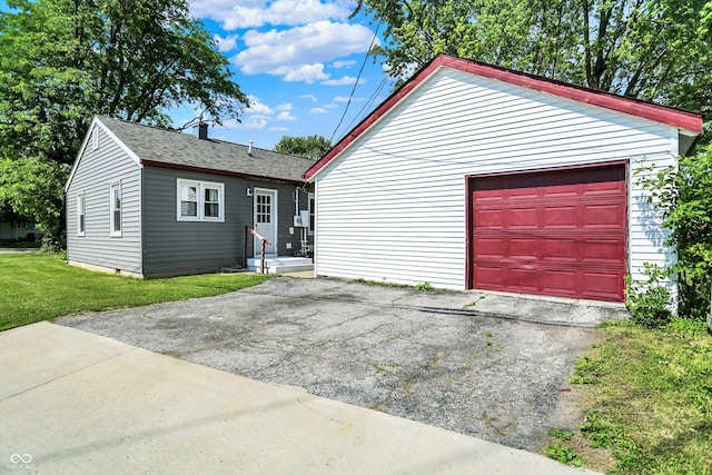 11 14th St, Franklin, IN 46131 - view of front of property featuring driveway, a garage, a shingled roof, a front lawn, and an outdoor structure