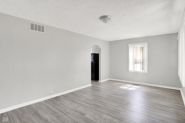 11 14th St, Franklin, IN 46131 - unfurnished room with arched walkways, a textured ceiling, wood finished floors, and baseboards