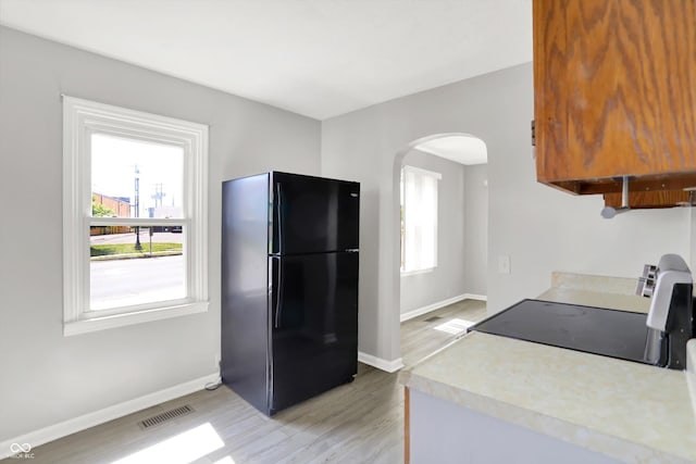 11 14th St, Franklin, IN 46131 - kitchen with freestanding refrigerator, arched walkways, light wood finished floors, range, and baseboards