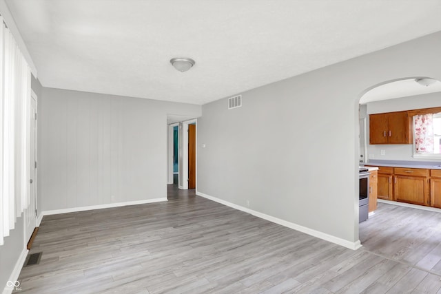 11 14th St, Franklin, IN 46131 - empty room with arched walkways, light wood-style flooring, and baseboards