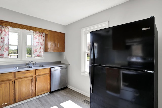 11 14th St, Franklin, IN 46131 - kitchen featuring freestanding refrigerator, dishwasher, a sink, and brown cabinets