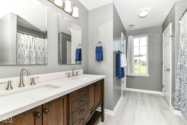 12343 Slate Dr, Fishers, IN 46037 - bathroom featuring wood finished floors, double vanity, and baseboards