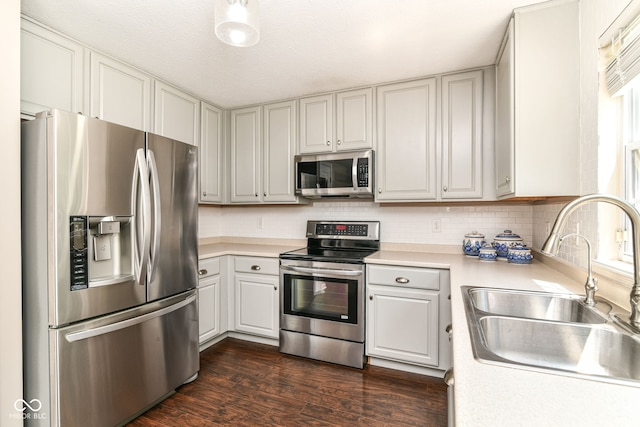 12343 Slate Dr, Fishers, IN 46037 - kitchen featuring stainless steel appliances, a sink, light countertops, backsplash, and dark wood finished floors