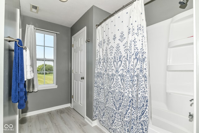 12343 Slate Dr, Fishers, IN 46037 - full bathroom featuring wood finished floors, baseboards, and shower / tub combo with curtain