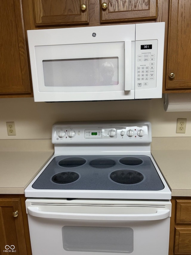 5148 Constitution Ct, Columbus, IN 47203 - kitchen with white appliances, light countertops, and brown cabinets
