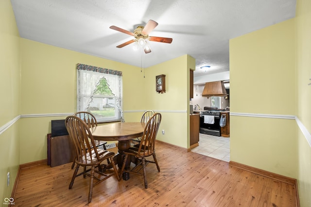 3210 Flintwood Dr, Columbus, IN 47203 - dining area with light wood-type flooring, a ceiling fan, and baseboards