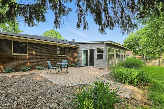 8635 Bishops Ln, Indianapolis, IN 46217 - rear view of house with a patio area, brick siding, and a chimney