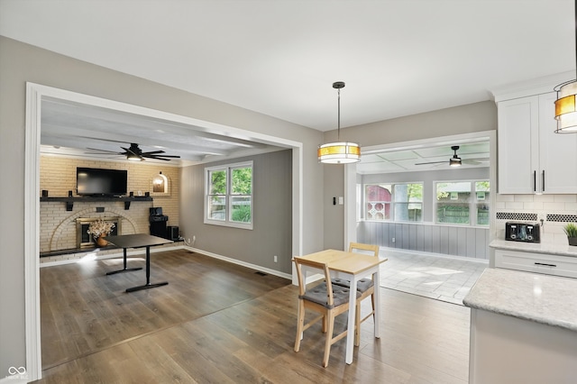 8635 Bishops Ln, Indianapolis, IN 46217 - kitchen with ceiling fan, white cabinets, a fireplace, wood finished floors, and beam ceiling