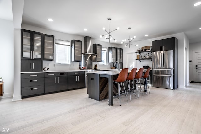 1622 Cornell Ave, Indianapolis, IN 46202 - kitchen with stainless steel refrigerator, wall chimney exhaust hood, a chandelier, a kitchen bar, and light countertops