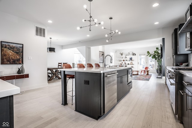 1622 Cornell Ave, Indianapolis, IN 46202 - kitchen with appliances with stainless steel finishes, a kitchen breakfast bar, recessed lighting, a center island with sink, and light countertops