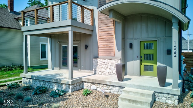 1622 Cornell Ave, Indianapolis, IN 46202 - doorway to property featuring a balcony, board and batten siding, stone siding, and french doors