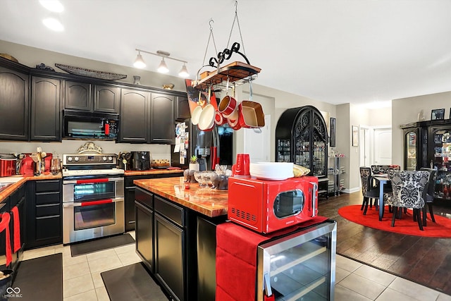 9605 Treyburn Green Way, Indianapolis, IN 46239 - kitchen featuring black appliances, wine cooler, light tile patterned floors, a kitchen island, and butcher block counters