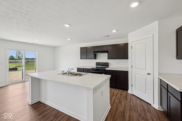 1304 Vera Blvd, Danville, IN 46122 - kitchen with black range, a sink, dark wood-type flooring, a center island with sink, and light countertops