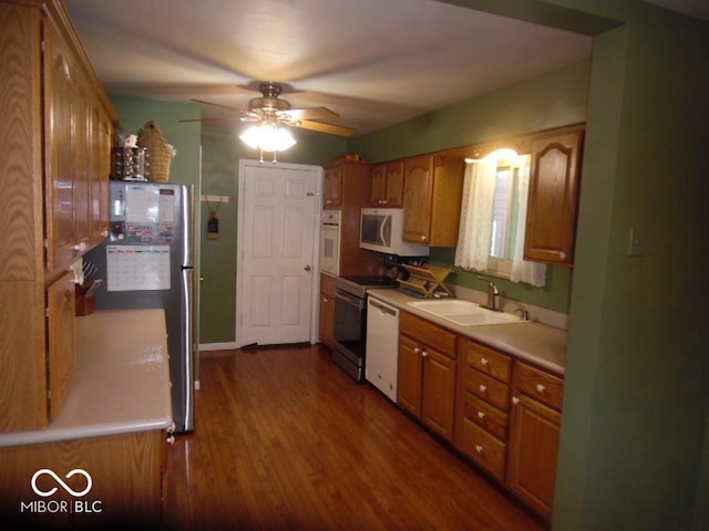 213 S Coventry Dr, Anderson, IN 46012 - kitchen featuring a sink, white appliances, dark wood finished floors, a ceiling fan, and brown cabinetry