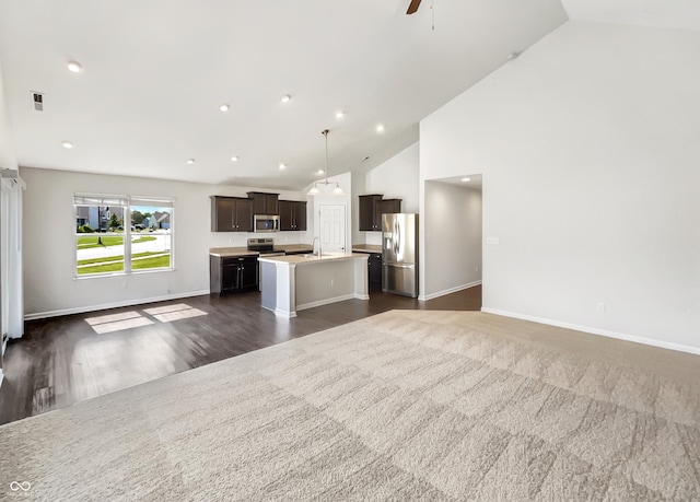 10112 James Run Dr, Indianapolis, IN 46239 - kitchen with open floor plan, stainless steel appliances, a center island with sink, lofted ceiling, and light countertops