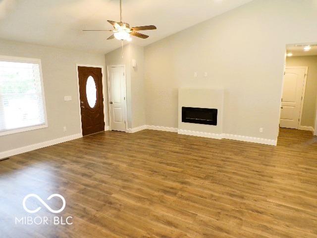 3204 N County Road 900 E, Seymour, IN 47274 - unfurnished living room featuring lofted ceiling, ceiling fan, baseboards, and wood finished floors