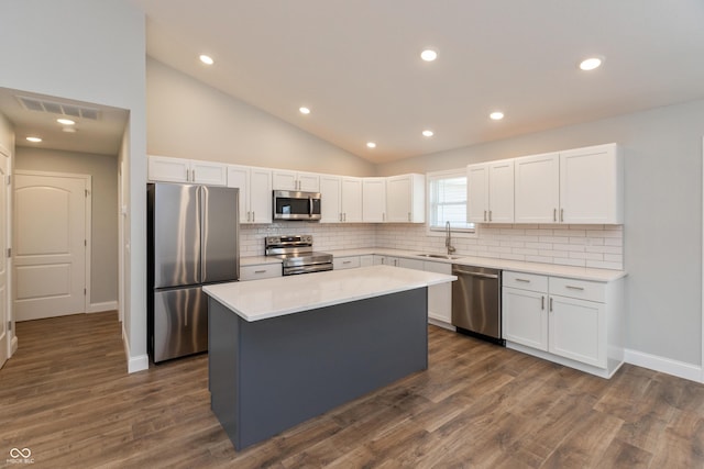 3204 N County Road 900 E, Seymour, IN 47274 - kitchen with appliances with stainless steel finishes, tasteful backsplash, a center island, white cabinets, and vaulted ceiling