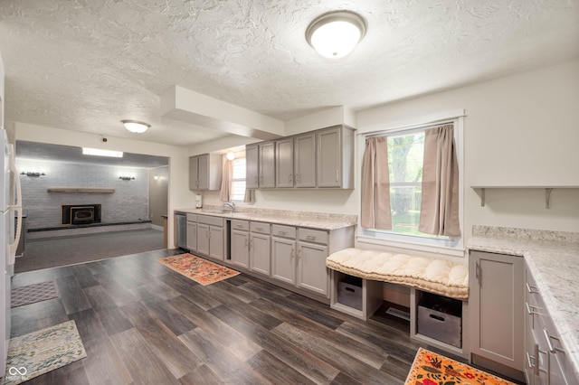 106 N Jamalee Way, Pendleton, IN 46064 - kitchen featuring a sink, gray cabinets, a textured ceiling, and a brick fireplace