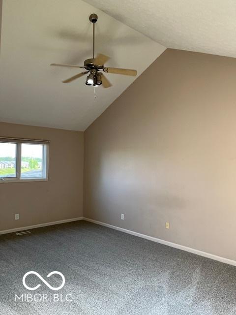 7707 River Rd Unit 10, Indianapolis, IN 46240 - empty room featuring ceiling fan, lofted ceiling, dark carpet, and baseboards