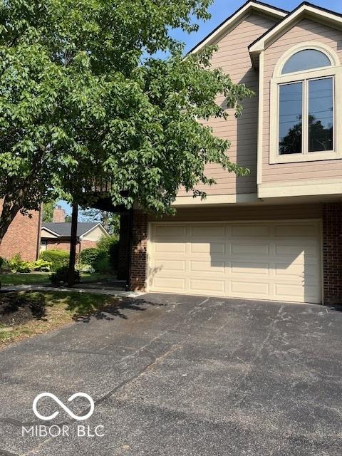 7707 River Rd Unit 10, Indianapolis, IN 46240 - view of side of home with brick siding, driveway, and a garage