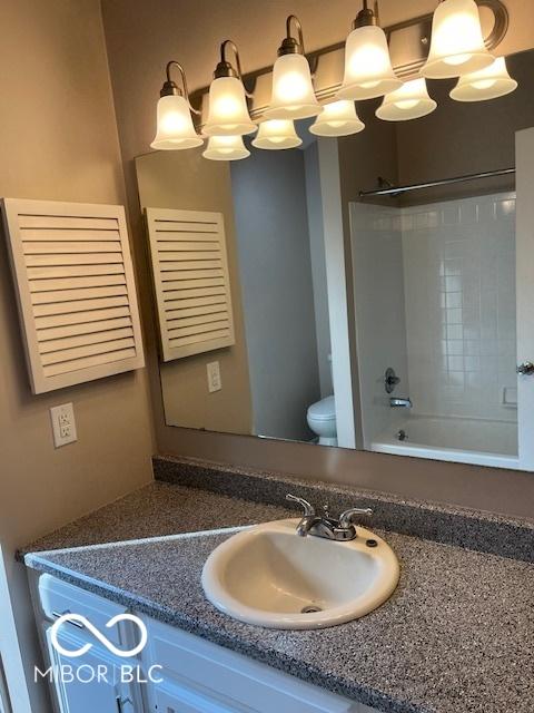 7707 River Rd Unit 10, Indianapolis, IN 46240 - bathroom featuring vanity, toilet, and tub / shower combination