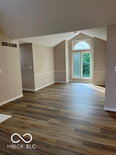 7707 River Rd Unit 10, Indianapolis, IN 46240 - spare room with lofted ceiling, baseboards, and dark wood finished floors
