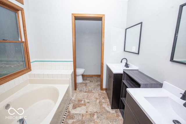 5840 N State Highway 7, Scipio, IN 47273 - full bathroom with stone tile flooring, toilet, a garden tub, two vanities, and baseboards