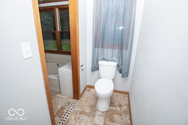 5840 N State Highway 7, Scipio, IN 47273 - bathroom featuring a garden tub, toilet, baseboards, and stone finish floors