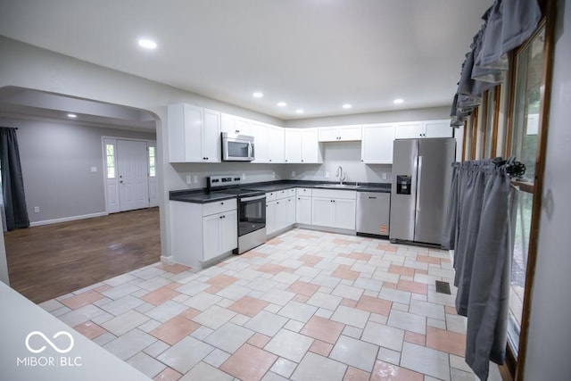 5840 N State Highway 7, Scipio, IN 47273 - kitchen featuring stainless steel appliances, a sink, dark countertops, arched walkways, and recessed lighting