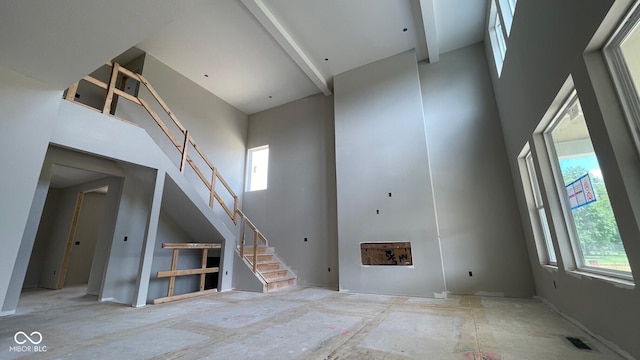 1919 Delp Ct, Avon, IN 46123 - unfurnished living room with a towering ceiling, plenty of natural light, and stairs