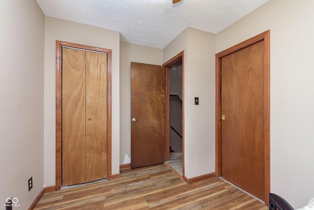 5110 S State Ave, Indianapolis, IN 46227 - unfurnished bedroom with light wood-style flooring, a closet, baseboards, and a textured ceiling