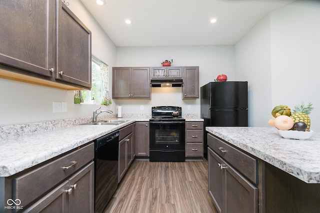 5335 Rum Cherry Way, Indianapolis, IN 46237 - kitchen featuring black appliances, range hood, wood finished floors, dark brown cabinets, and light countertops