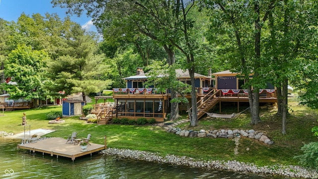 8426 N Chickadee Dr, Morgantown, IN 46160 - back of property featuring stairs, a deck with water view, a sunroom, and a yard