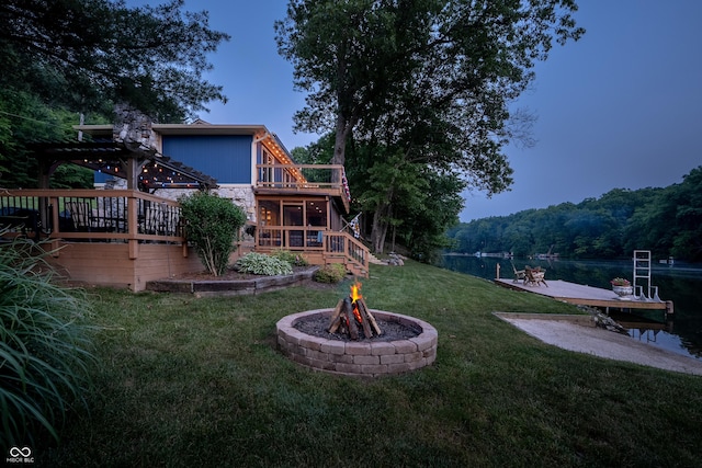 8426 N Chickadee Dr, Morgantown, IN 46160 - view of green lawn featuring a fire pit, a deck with water view, a pergola, a forest view, and stairs