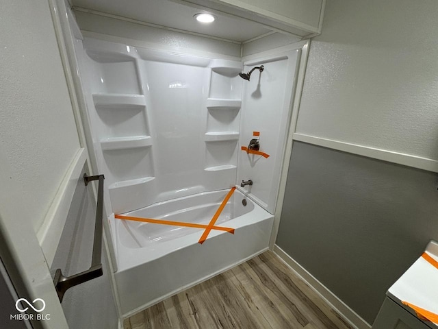 724 Iroquois St, Anderson, IN 46012 - bathroom featuring wood finished floors, shower / washtub combination, a textured wall, and baseboards
