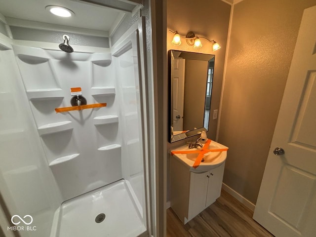 724 Iroquois St, Anderson, IN 46012 - bathroom featuring wood finished floors, a stall shower, vanity, and baseboards