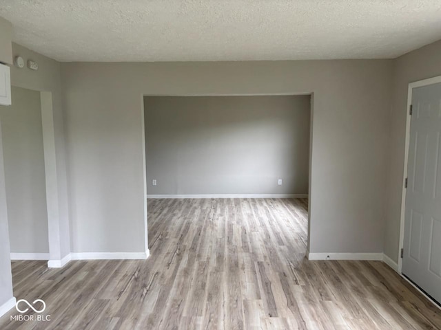 724 Iroquois St, Anderson, IN 46012 - spare room featuring light wood-type flooring, a textured ceiling, and baseboards