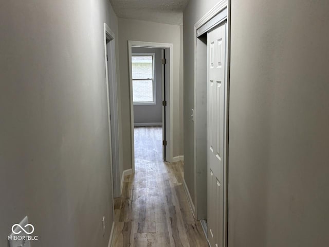 724 Iroquois St, Anderson, IN 46012 - hallway featuring light wood-type flooring, baseboards, and a textured ceiling