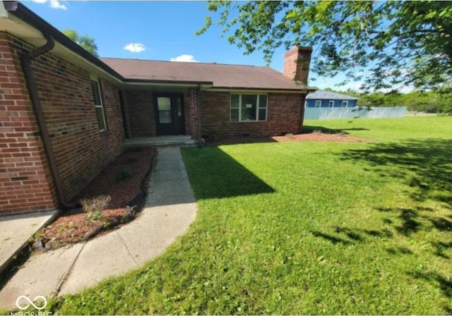 724 Iroquois St, Anderson, IN 46012 - exterior space with a chimney, brick siding, and a front lawn