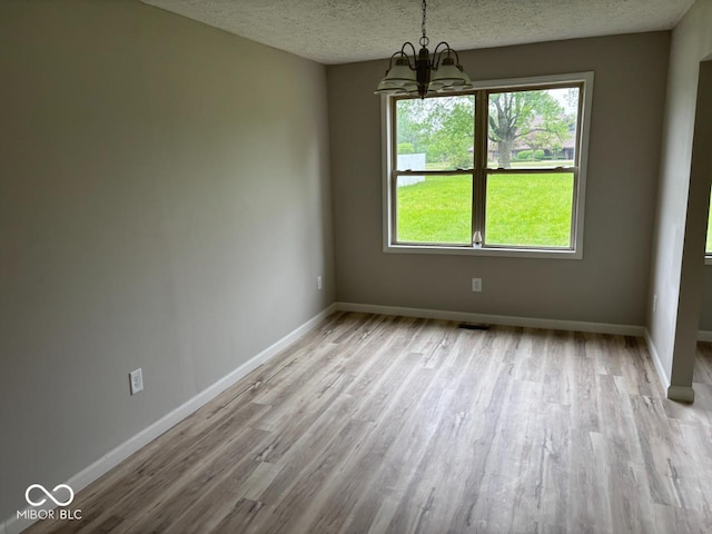 724 Iroquois St, Anderson, IN 46012 - unfurnished dining area with a chandelier, wood finished floors, a textured ceiling, and baseboards