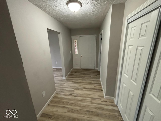 724 Iroquois St, Anderson, IN 46012 - hall featuring light wood-style flooring, a textured ceiling, and baseboards