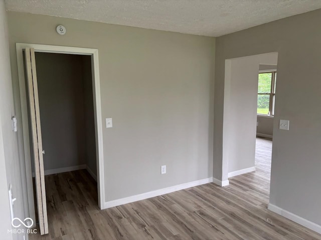 724 Iroquois St, Anderson, IN 46012 - spare room with wood finished floors, a textured ceiling, baseboards, and a smoke detector